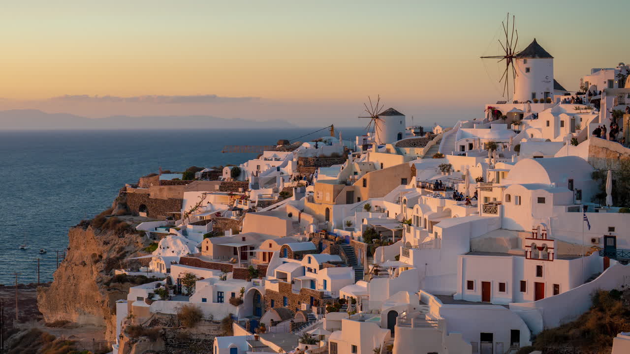 el lapso de tiempo, la isla de santorini en la hora dorada y la puesta de sol, los edificios blancos de la aldea de oia y el mar egeo