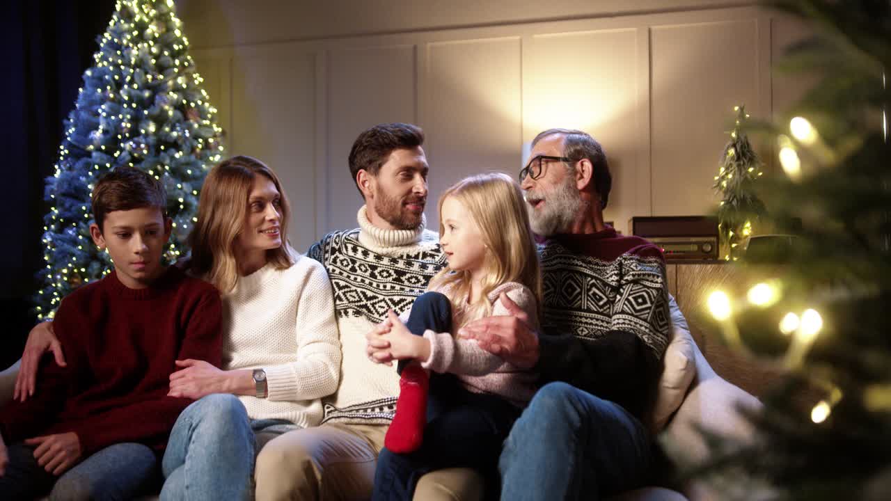 Portrait Of Happy Family Gathering Together At Cozy Home Near Decorated Glowing Xmas Tree Chatting, Smiling And Making Jokes On Christmas Eve In Evening