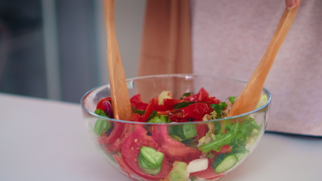 Mixing salad with wooden spoons