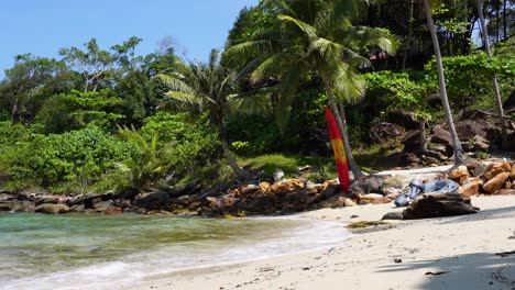 A-video-of-a-tropical-beach-surrounded-by-palm-trees-and-waves-from-the-sea,-located-at-Koh-Kood-Island-in-Thailand-in-Asia