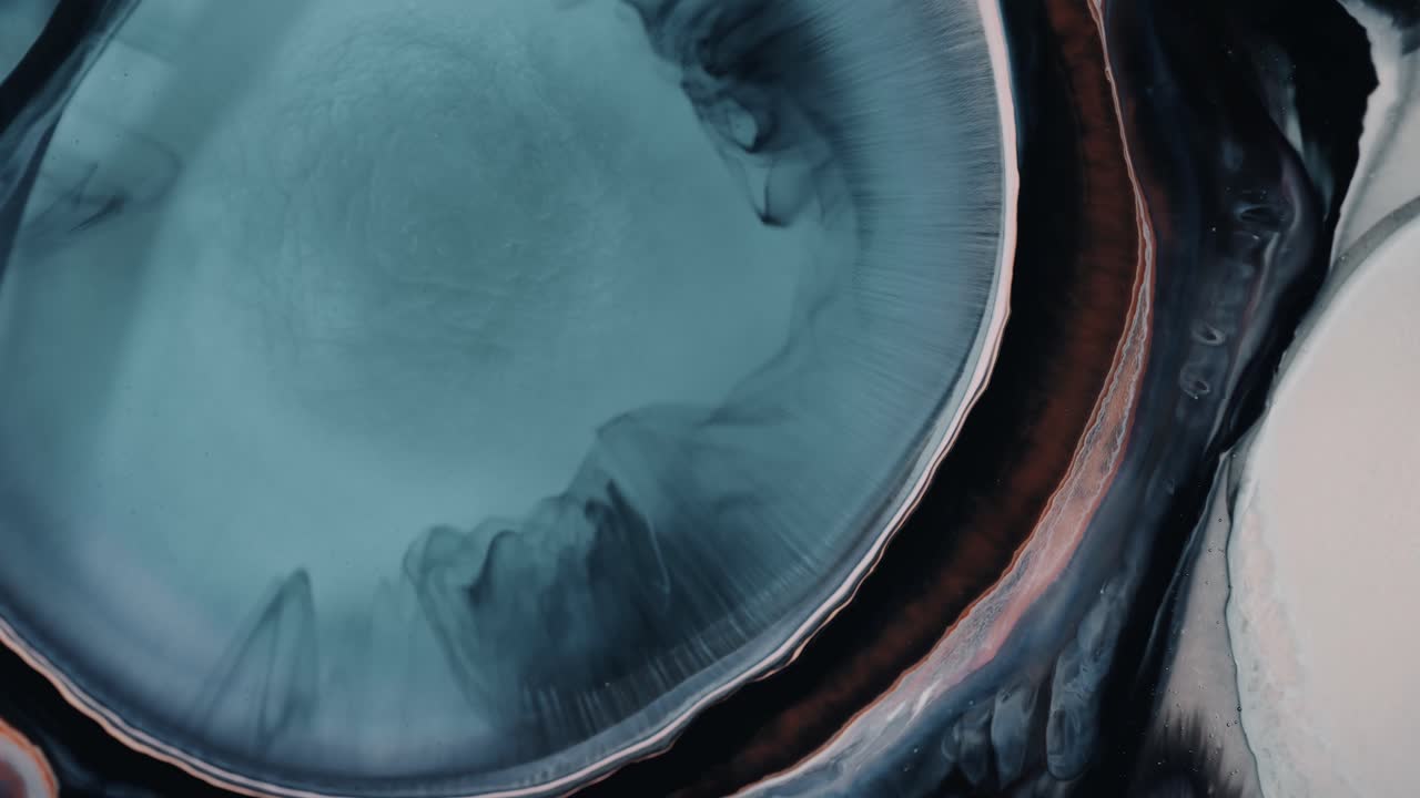 Inchiostro liquido multicolore sparso che crea una nebulosa.