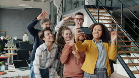 happy diverse team taking a selfie in modern office