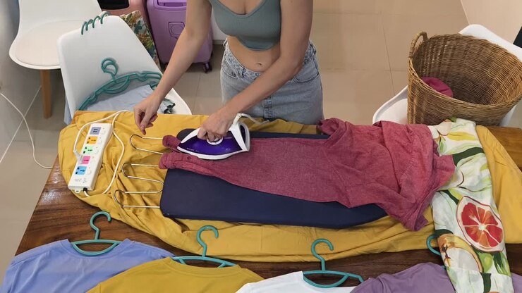 Woman ironing clothes at home