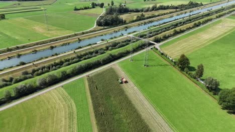 aerial tilt up of green agricultural fields during harvesting process in swiss countryside