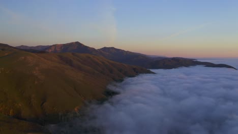 drone shots of pacific coast cliffs near big sur and carmel highlands california during marine fog layer and sunset