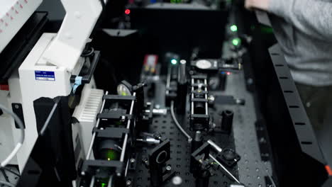 vertical pan over an optical table with different laser and mirror elements for precise scientific measurements