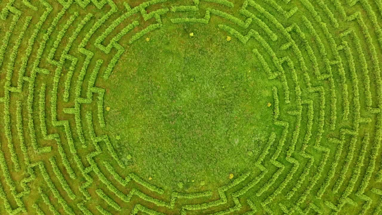 Clockwise top down aerial shot shows detailed maze in Latvian countryside view