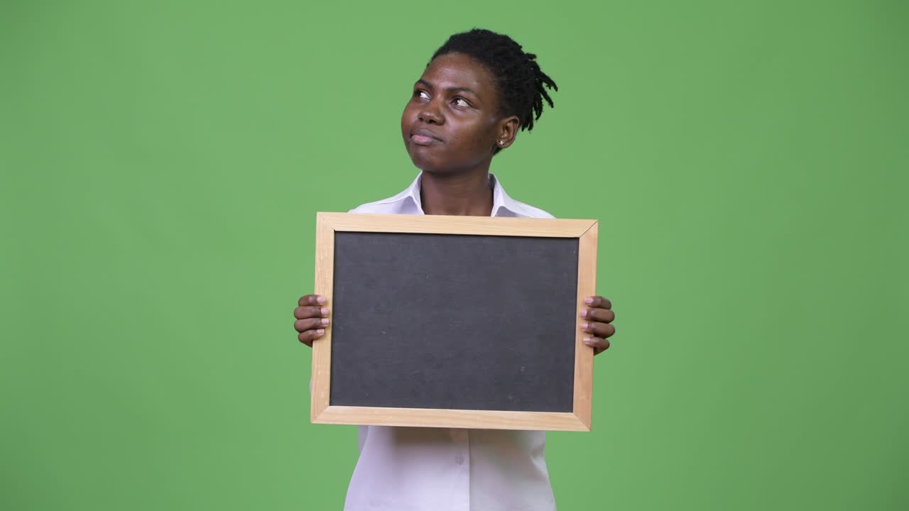 Young beautiful African businesswoman holding blackboard