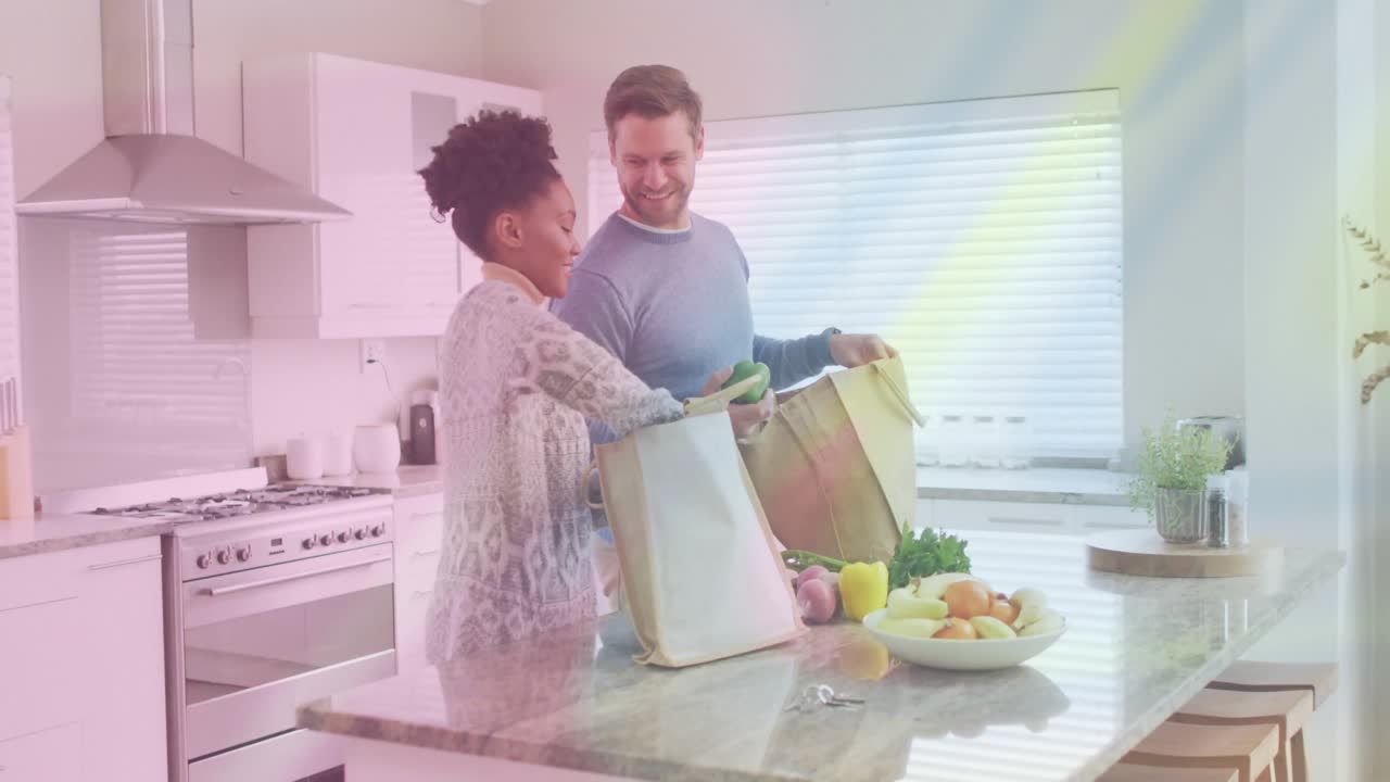 Casal descarregando compras na cozinha de casa, com gráficos animados de dados de saúde flutuando sobre os alimentos.