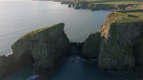 drone flyover sea stacks to bay with fishing boat at work stunning copper coast irelands beauty