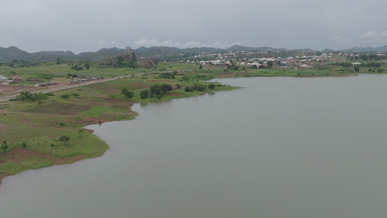 antena - comunidad junto al lago y granjas con edificio abandonado, enfoque hacia adelante
