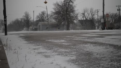 snow blows on the street in a small, quiet, quaint town in the midwest in kansas on a cold, december, winter day during christmas, holidays