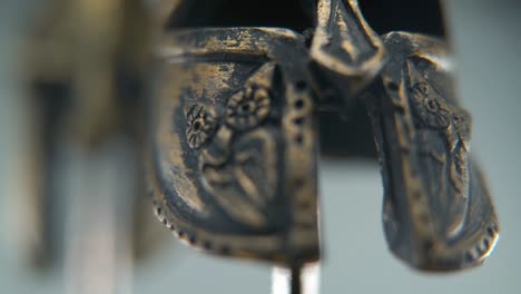 a close-up macro shot of a spartan design, ancient warrior metal bronze helmet, blurry depth of field, textured shapes, studio lighting, full hd cinematic video, hyper slow motion 120 fps, tilt up