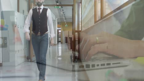 animación de manos usando una computadora portátil sobre un hombre de negocios caminando en el corredor de la oficina