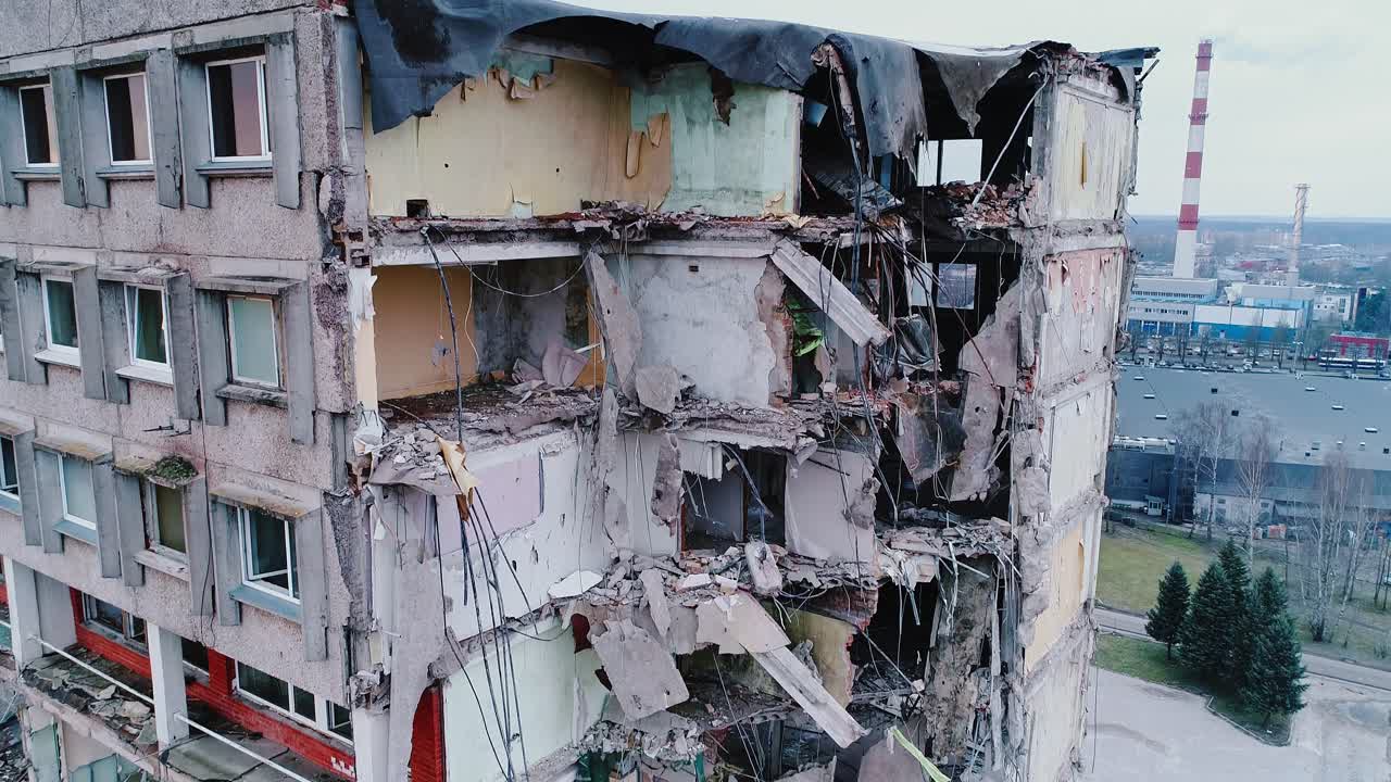 High-rise ruin cut open like dollhouse, showing damage, debris and hollow spaces