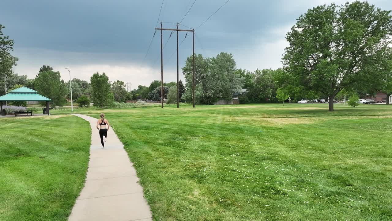 Running quickly through a park along a running path a young woman is training. Self improvement and a healthy lifestyle even when you are alone. Quick and agile runner