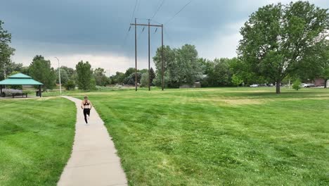 running quickly through a park along a running path a young woman is training. self improvement and a healthy lifestyle even when you are alone. quick and agile runner