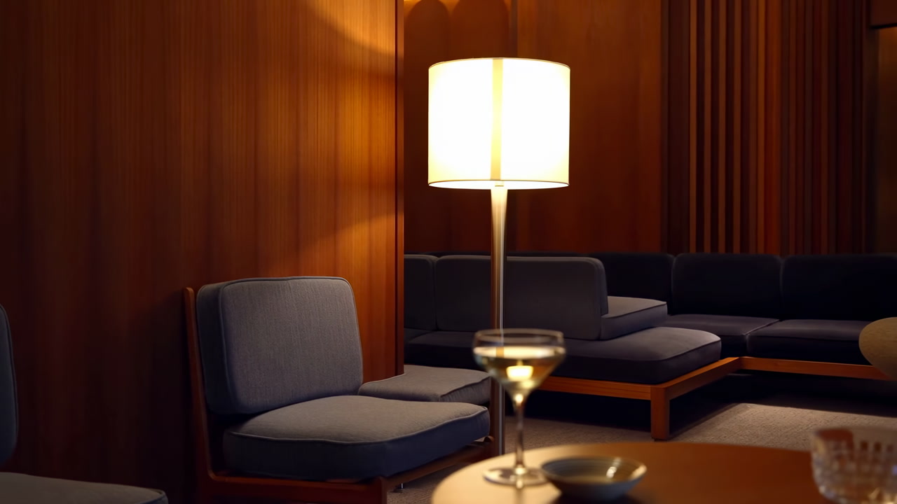 Moody Retro Hotel Lounge Warm Lamp. Soft Amber Light Bathes Wood Paneling And Blue Upholstered Seating Low