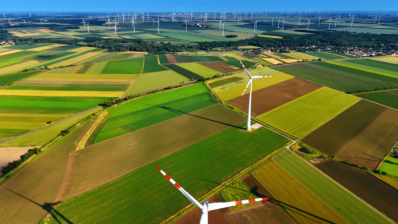 Picturesque agricultural fields with wind farms. Producing green energy from wind power. Aerial view.