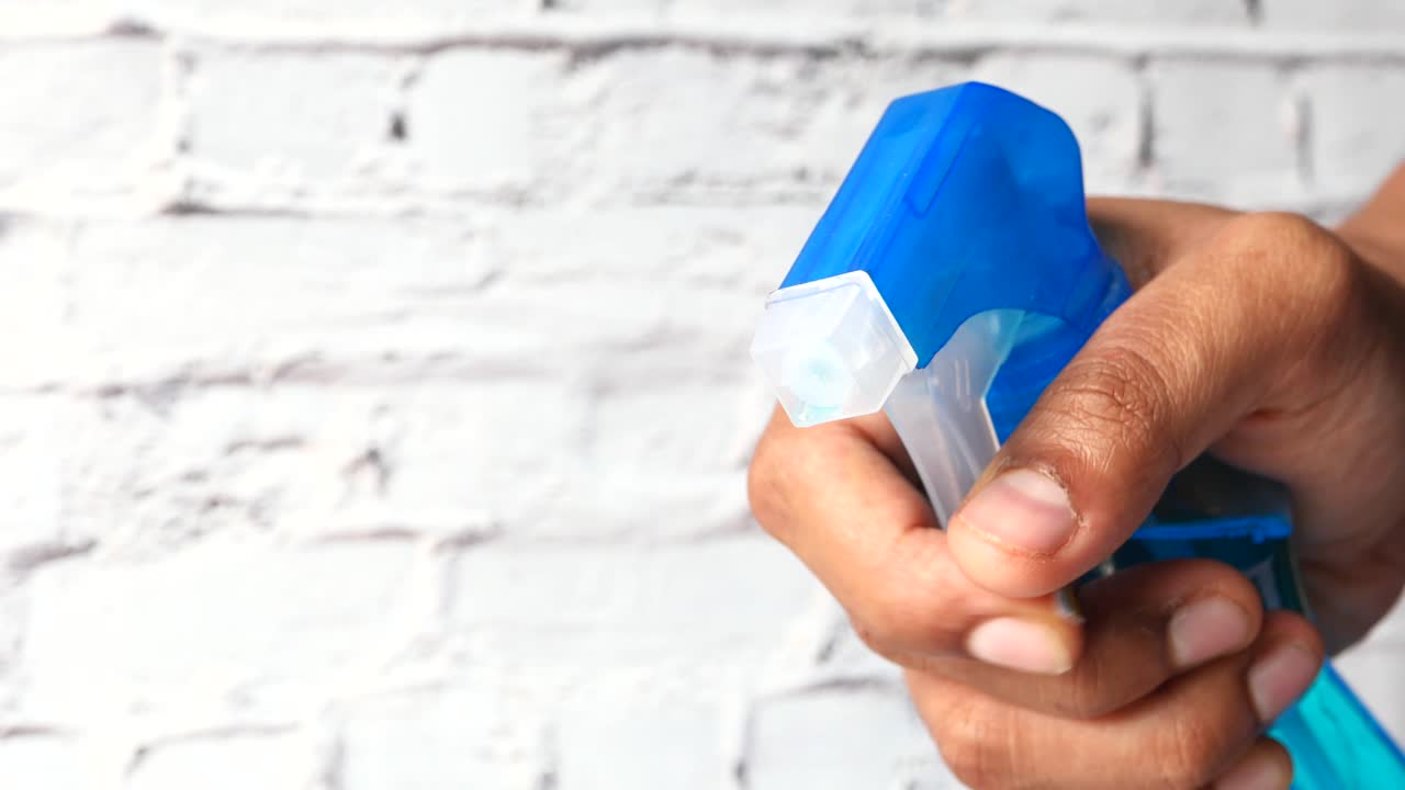 파란 스프레이 병을 들고 있는 손