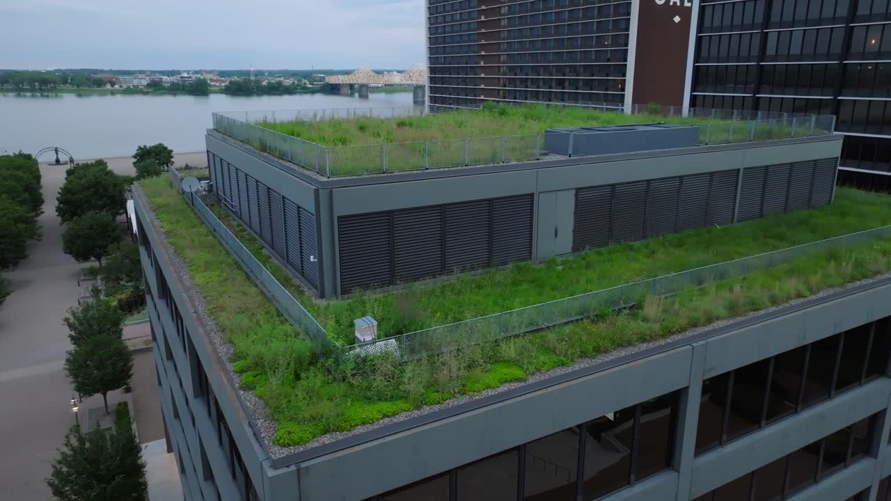 Telhado verde em arranha-céu urbano com rio ao fundo.