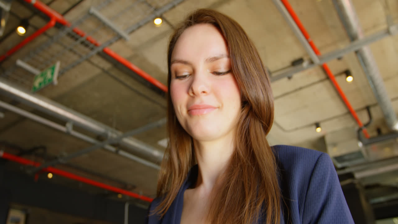 vista de ángulo bajo de una joven mujer de negocios caucásica trabajando en una tableta digital en una oficina moderna 4k