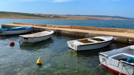 pan shot on several lonely fishing boats floating on clear adriatic sea water with small waves, marvelous background