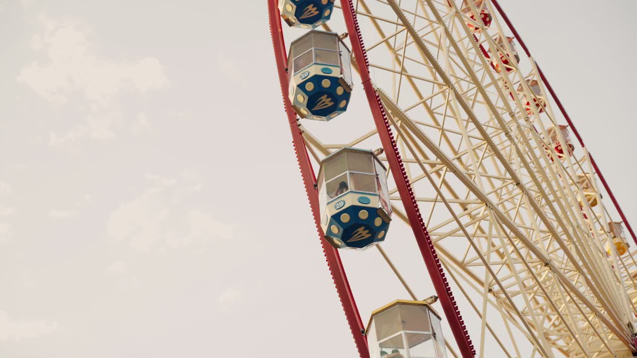la gran rueda de ferris en el parque de atracciones gira contra el cielo nublado