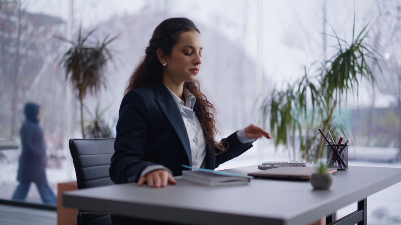 Closeup businesswoman start work sitting at desk. Serious lady opening laptop