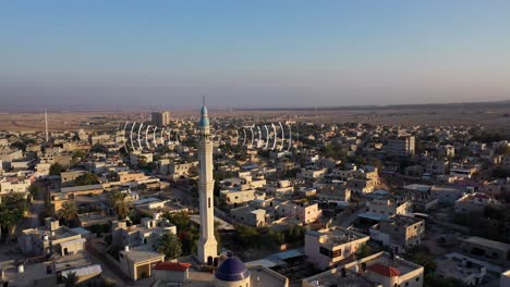 aerial view of a town with a mosque and radio waves