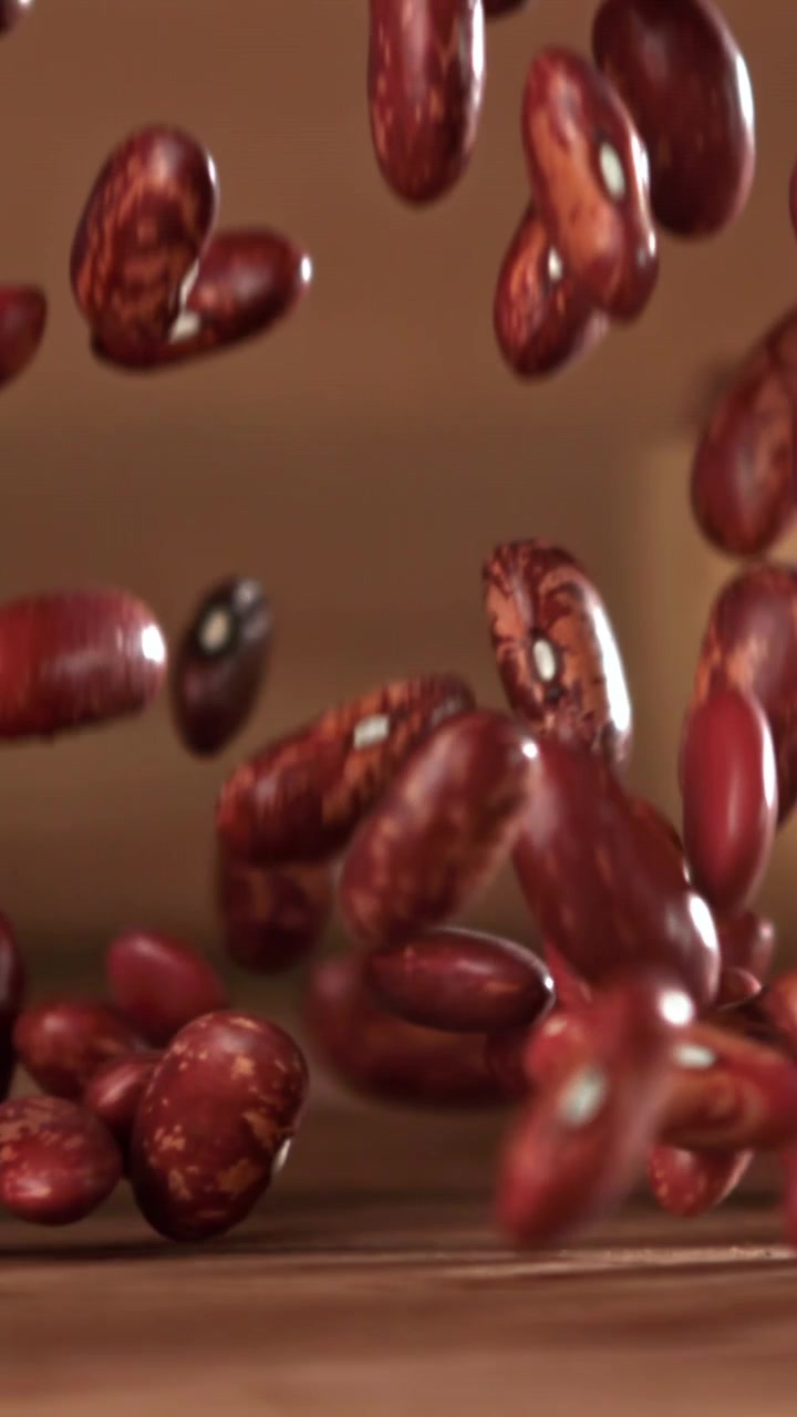 Red Kidney Beans Falling in Slow Motion onto a Wooden Surface