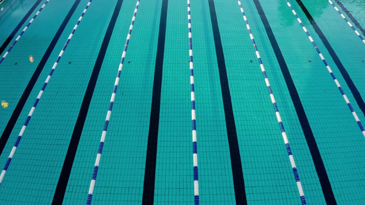 Tomada Aérea Lenta de Drone Sobre Piscina Exterior Vazia com Raias em Reykjavik, Islândia. A Água Turquesa Está Calma e Límpida