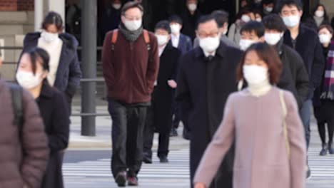 commuters waling crowded tokyo station on the way to work