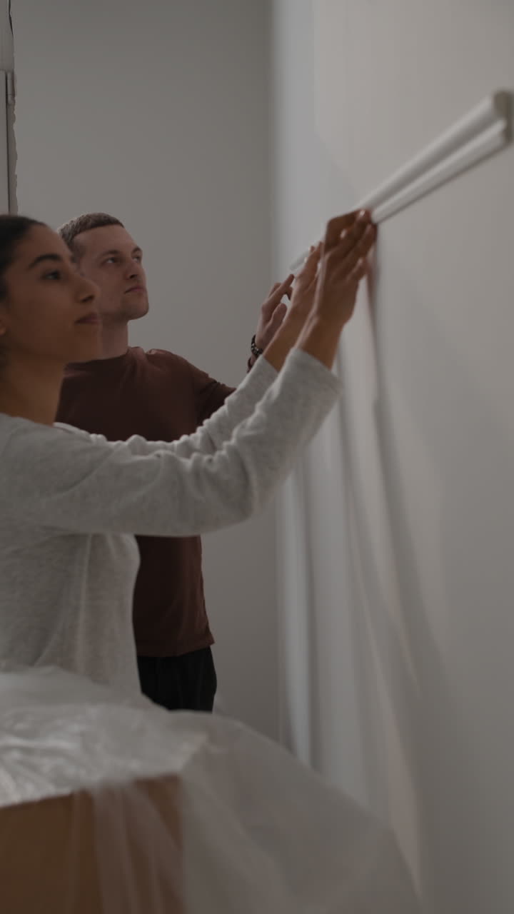 Couple Installing Wall Trim During Home Renovation