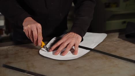 leather craftsman cutting leather pattern