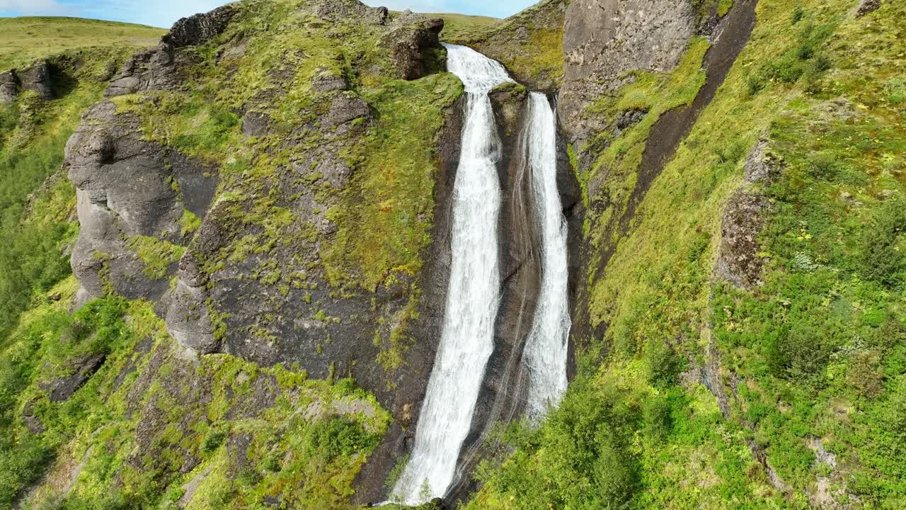 cataratas dobles altas en islandia durante el verano con un paisaje verde exuberante slomo