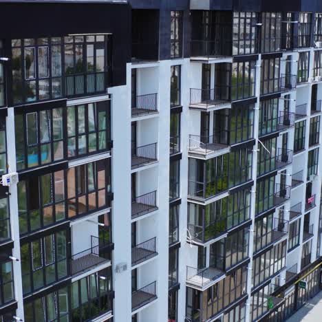 modern apartment building in new city district. exterior of a new multi-storey building with beautiful dark windows. aerial view