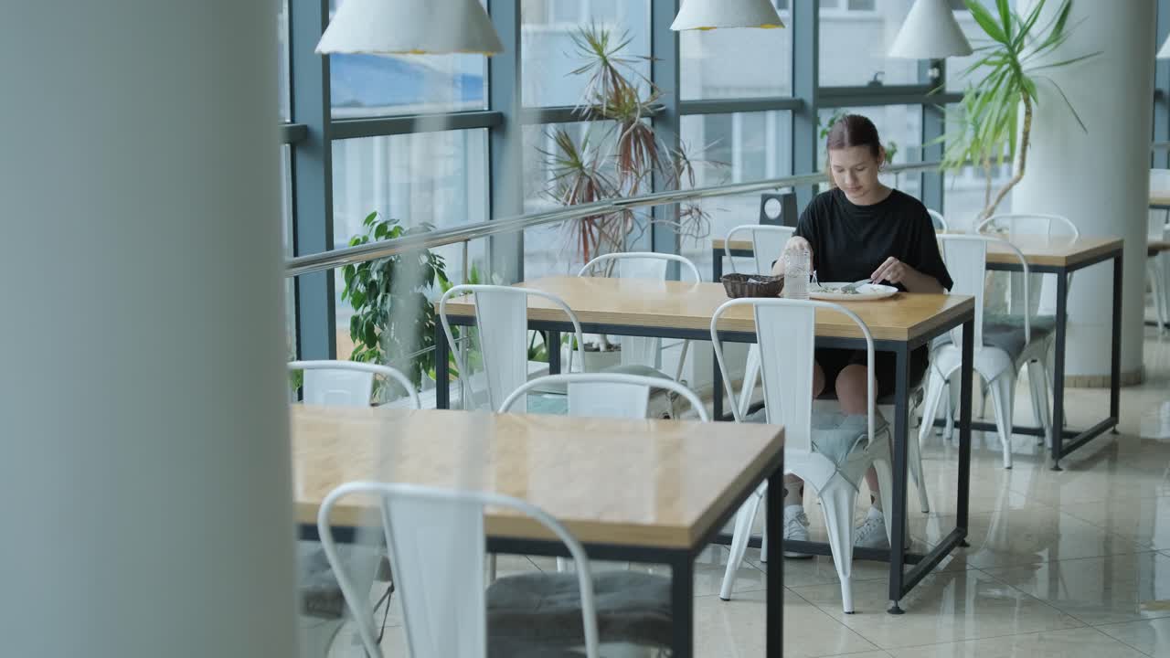 девушка ест салат в кафе.