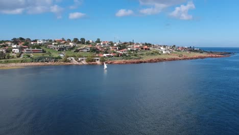 Barco-Navegando-Hacia-Tierra-Firme-En-Un-Día-De-Verano-Con-Aguas-Tranquilas