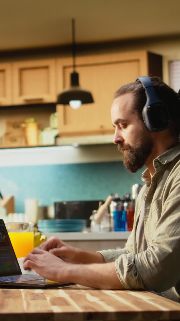 Vertical Video Man editing cinematic video content at home at a kitchen table