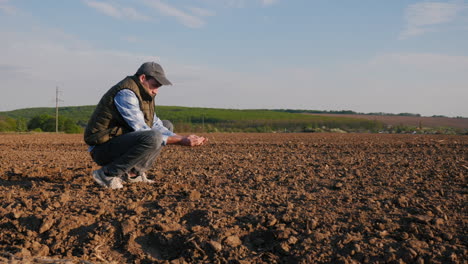 agricultor inspeccionando el suelo en el campo