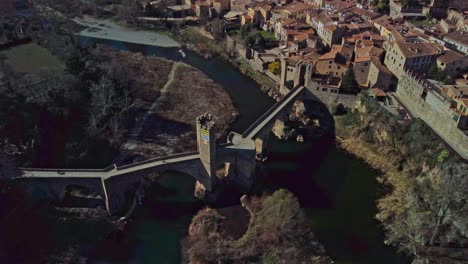 Medieval-stone-bridge-over-the-river-in-Besalu-town,-Girona,-Spain,-aerial-view