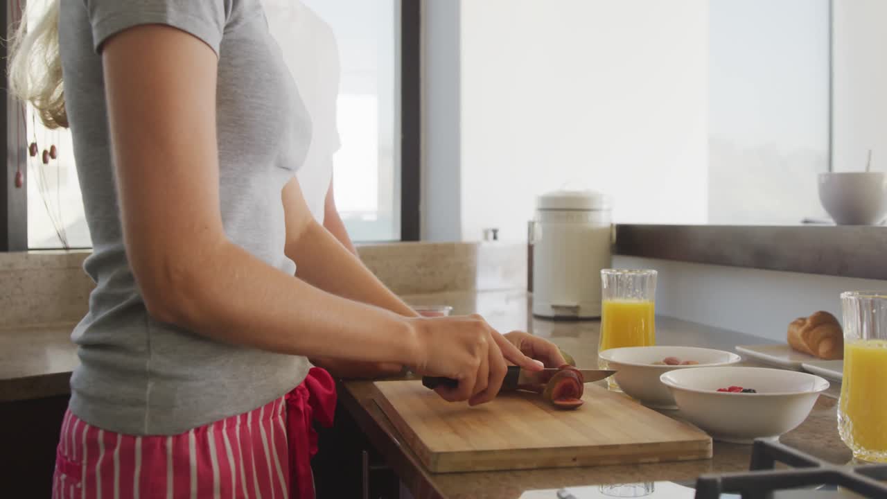 pareja caucásica cortando verduras en la cocina durante la pandemia de coronavirus covid19
