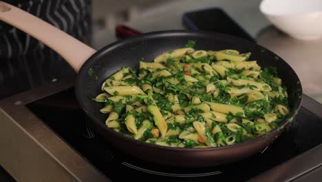 chef cooking pasta with spinach and parsley