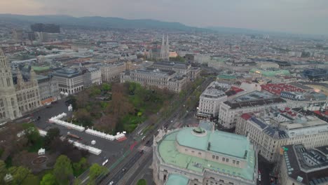 Aerial-shot-of-Vienna-City-Hall-with-view-of-the-cityscape-buildings,-evening