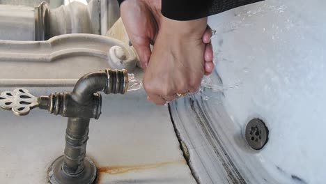 washing hands at a historical fountain