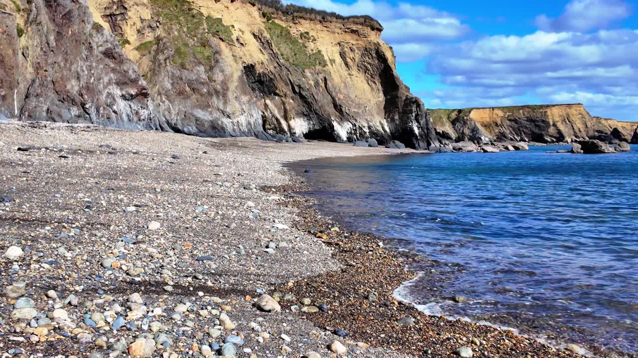 Irské pobřeží, plný příliv a jemné vlny na Copper Coast Waterford za klidného jarního rána.