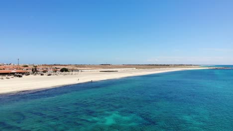 aerial view over beautiful blue turquoise ocean waters beside idyllic beach