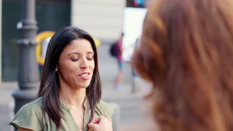 two women engage in an expressive outdoor conversation