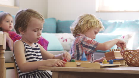 montessori-schüler arbeiten am schreibtisch mit hölzernen formen